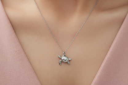 Silver turtle pendant necklace on a mannequin with a pink top