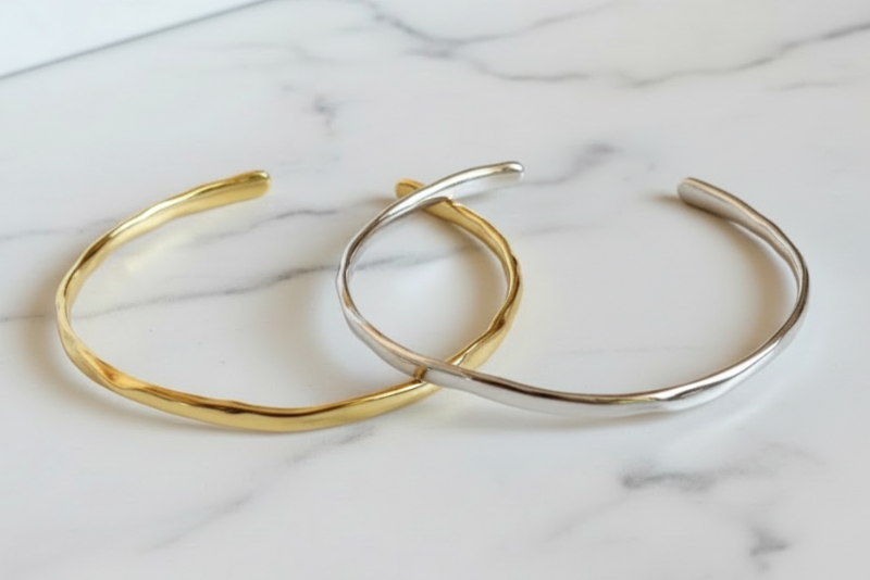 Gold and silver bangles on a textured surface