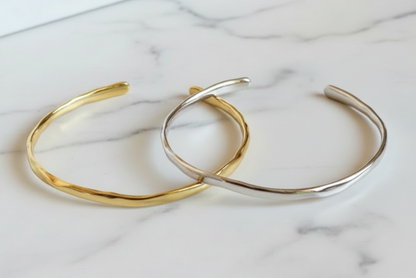 Gold and silver bangles on a textured surface