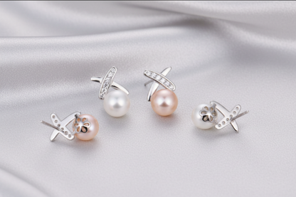 Pearl earrings with silver crosses on a beige background