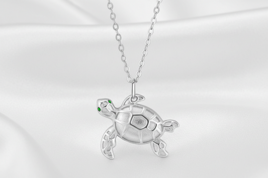 Silver turtle pendant necklace on a white background