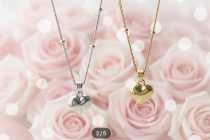 Two heart-shaped pendants on necklaces against a pink rose background