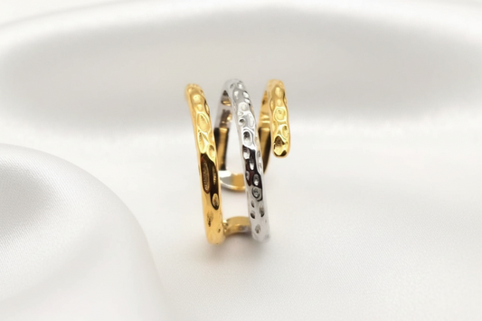 Two gold rings with textured designs on a white background
