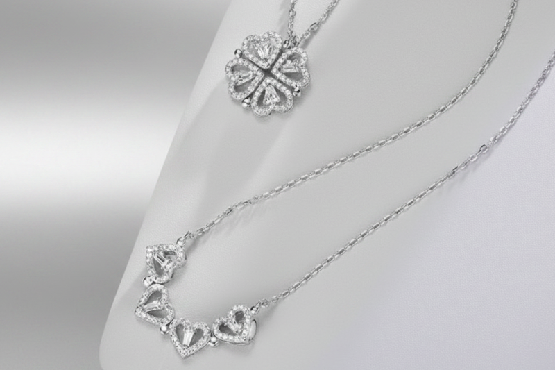 Silver necklaces with intricate designs on a neutral background