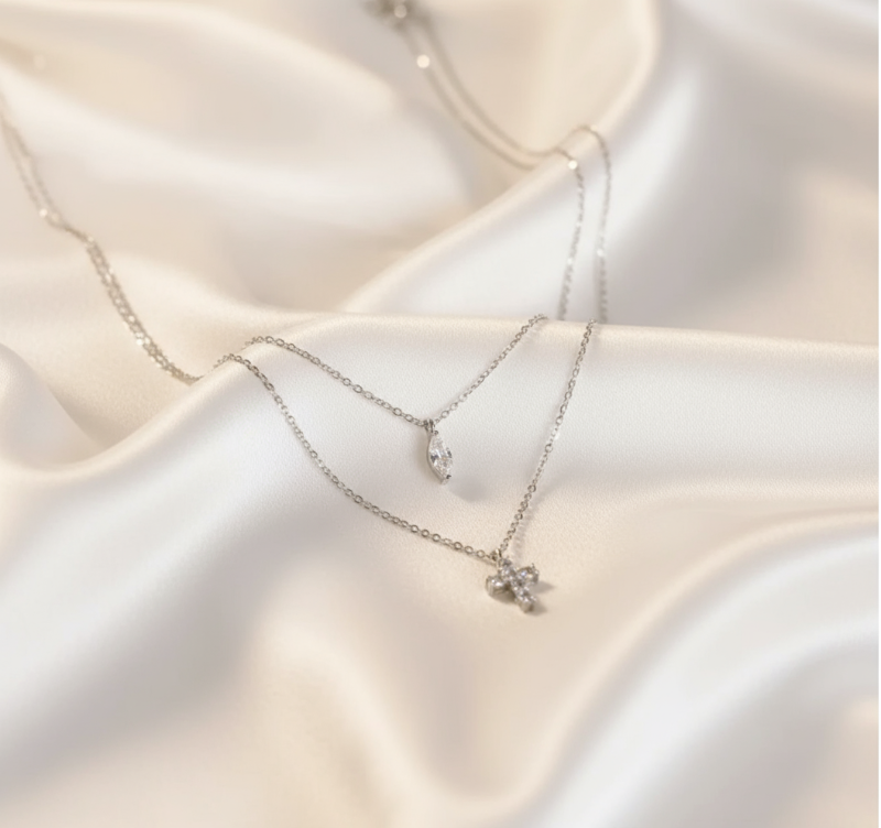 Necklaces on white silk background