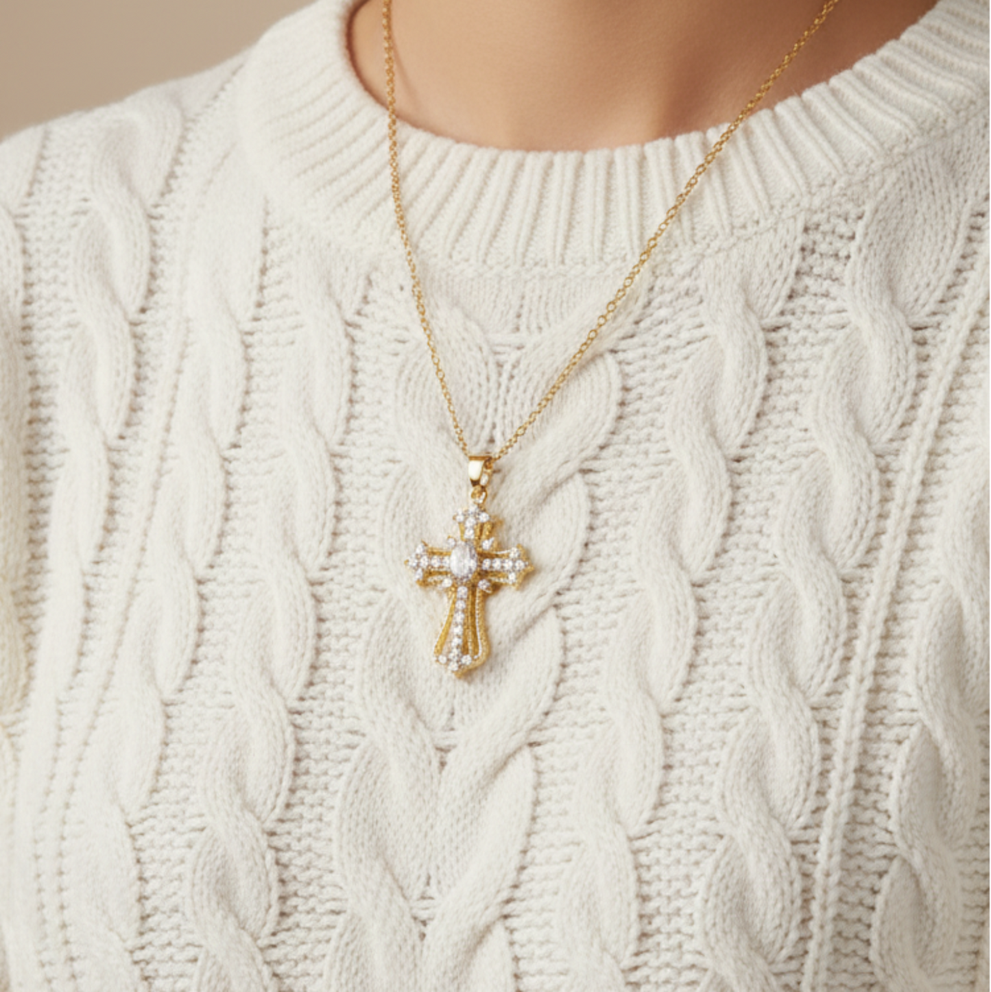 Ornate cross pendant over white jumper