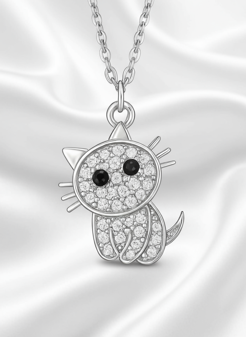 Silver cat-shaped pendant with black and clear gemstones on a white background