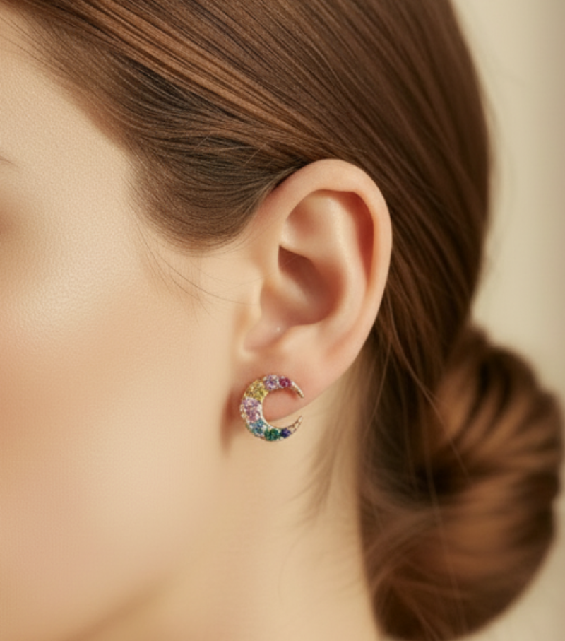 Small rainbow crescent earrings worn on ear