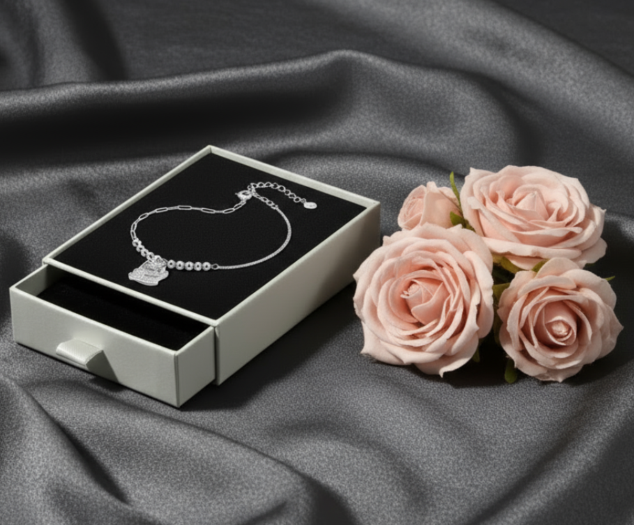 Sterling silver cat charm bracelet in white drawer box with blush rose